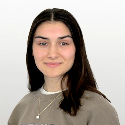Porträtbild Johanna Meilicke Junge Frau mit dunklen, langen Haaren lächelt in die Kamera. Sie trägt einen braunen Sweater und eine Kette um den Hals.