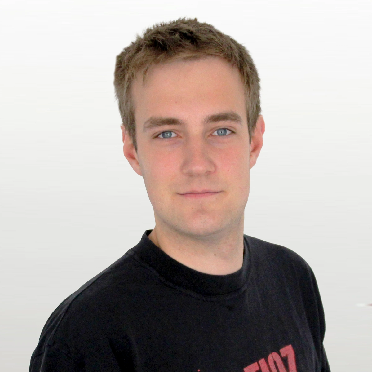 Junger Mann im T-Shirt schaut direkt in die Kamera